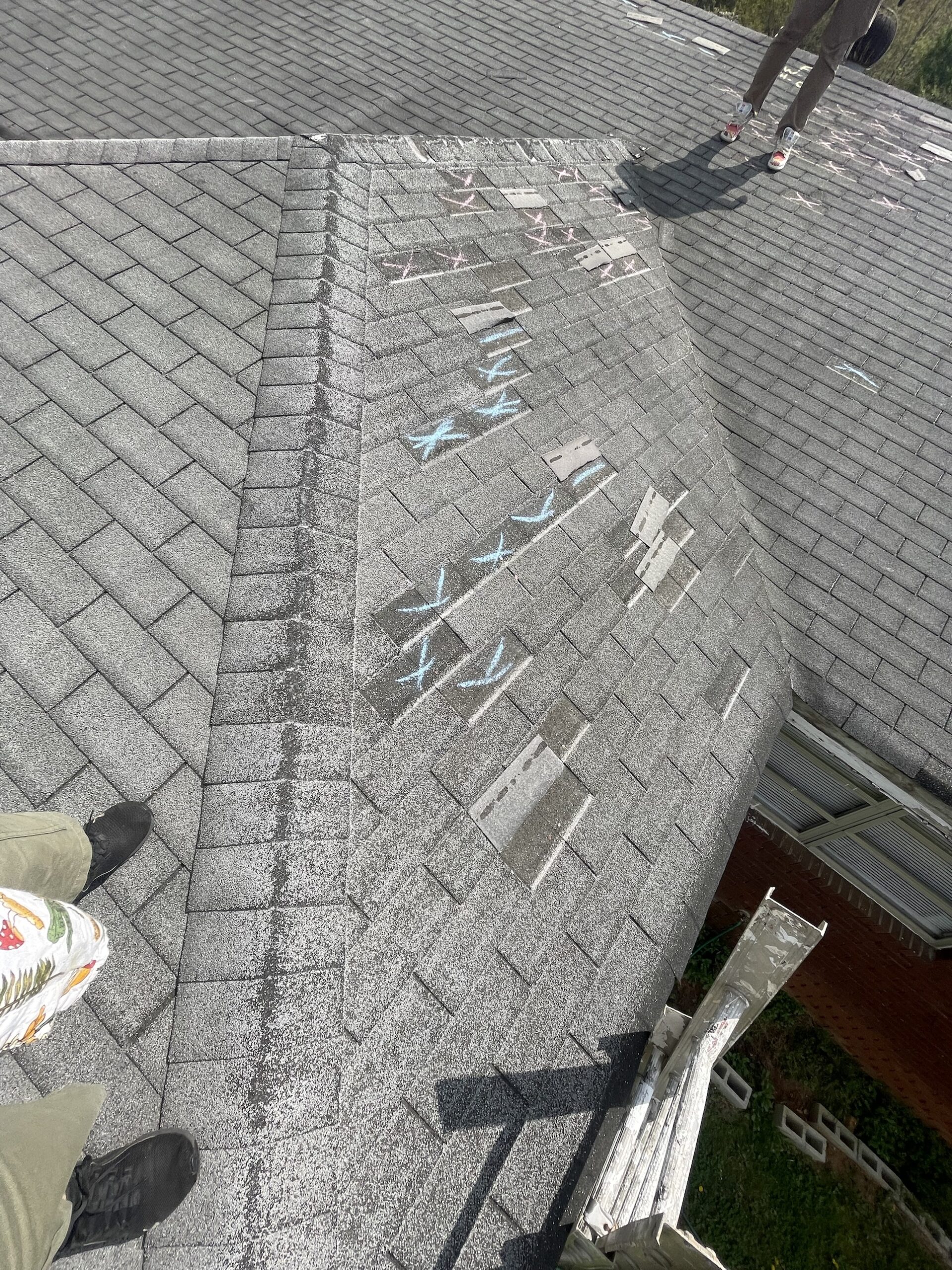 Wind-damaged shingles marked during the inspection of the Mableton roof