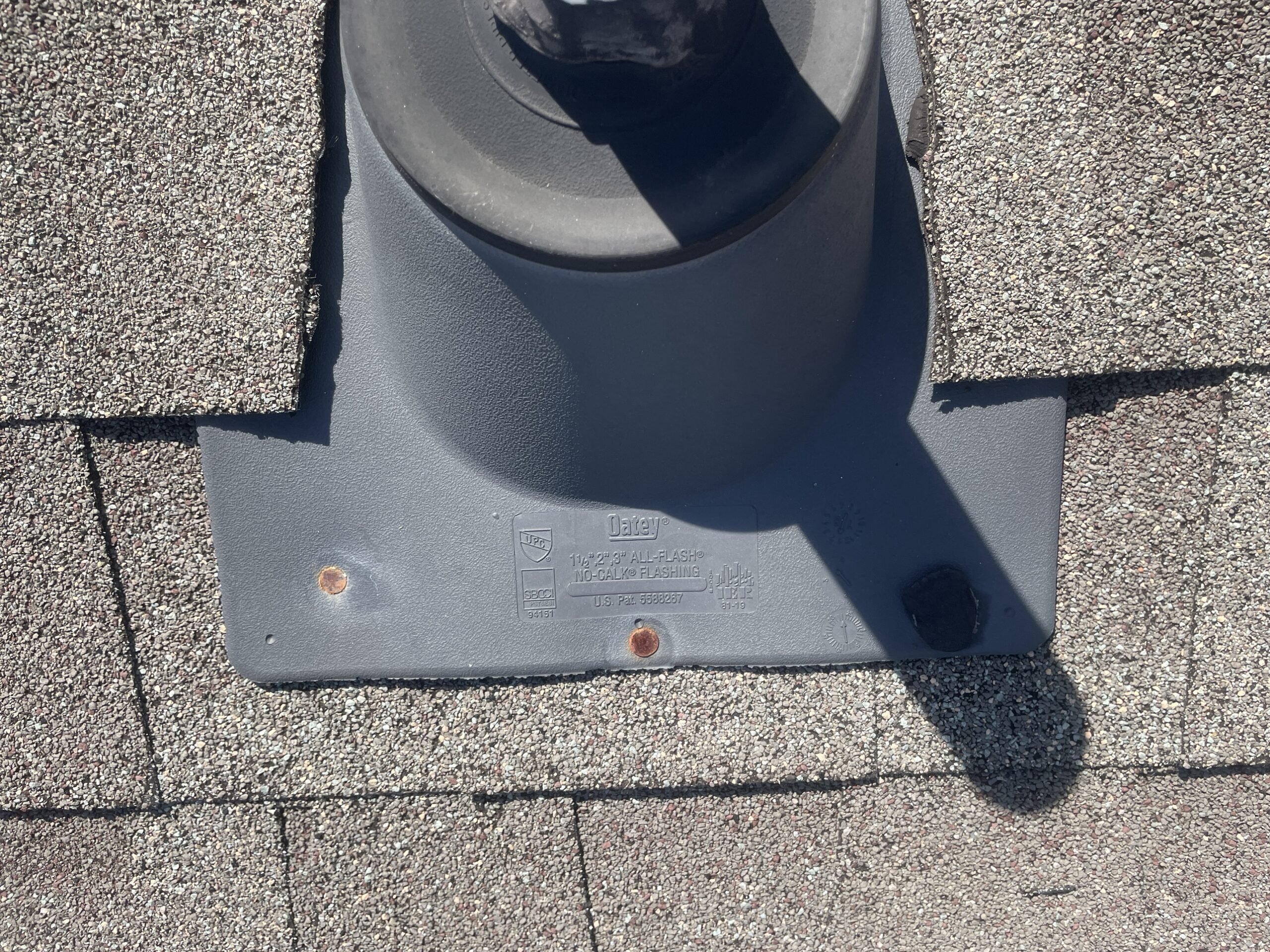 Rusting, exposed nail heads on roof flashing showing premature wear
