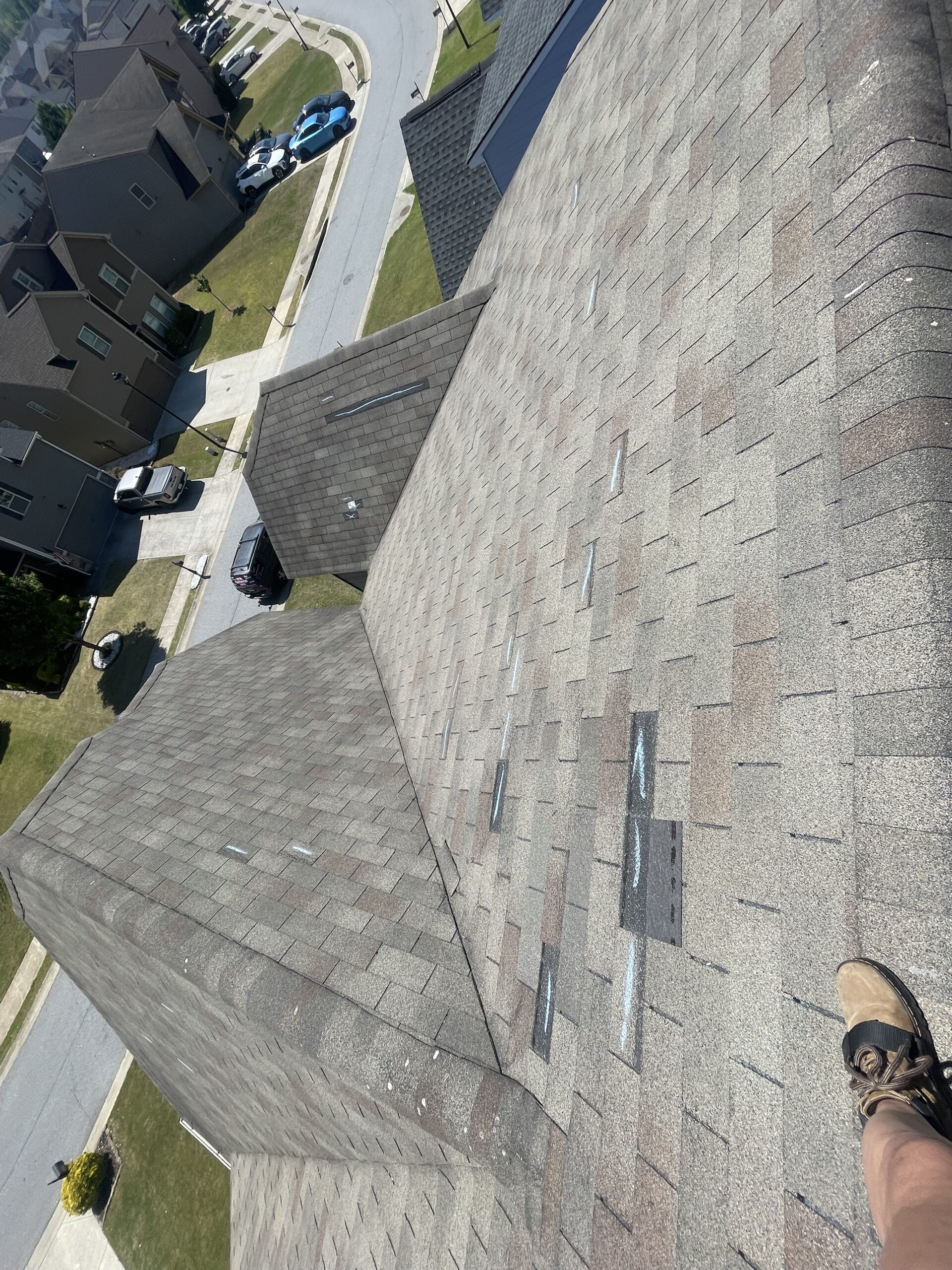 Aerial view of a roof with wind damage marked in chalk across multiple slopes
