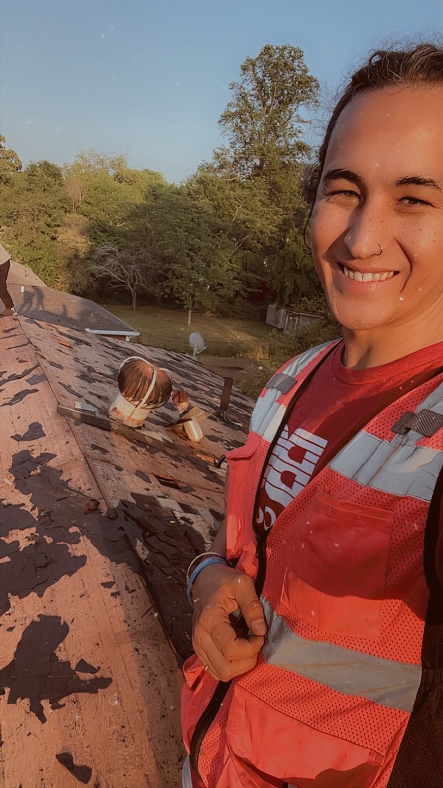 Tara Riggins, owner of Total Transformation Roofing, smiling on a roof during a job